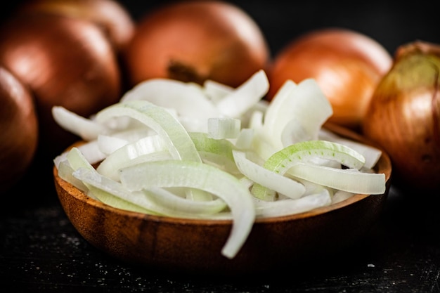 Cebollas picadas en un plato de madera