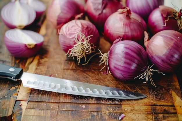 cebollas púrpuras frescas y un cuchillo en una tabla de cortar de madera rústica en el entorno de la cocina