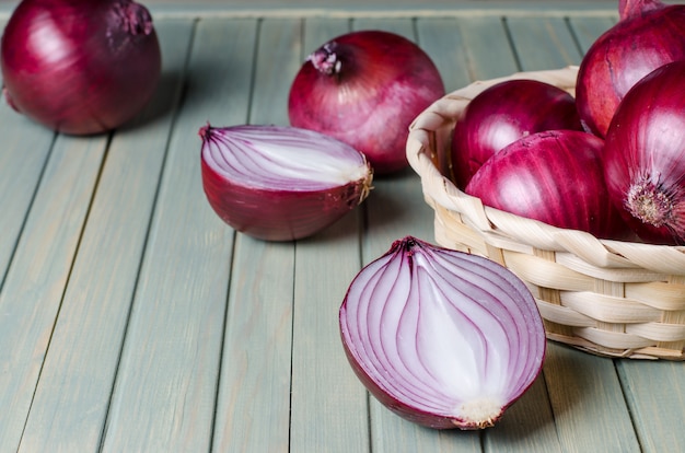 Cebollas rojas en una canasta de mimbre