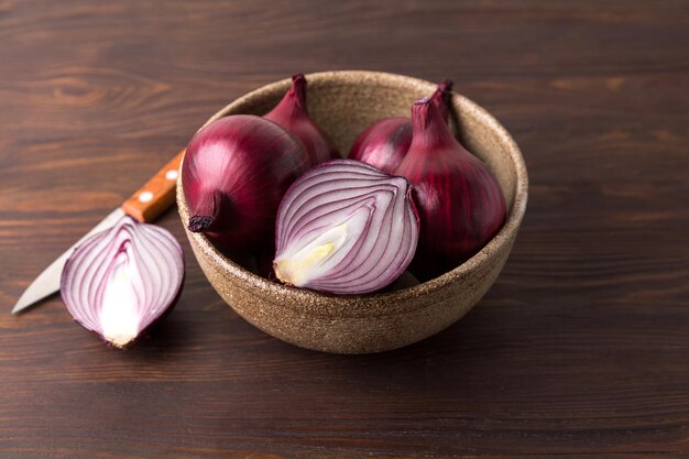 Cebollas rojas orgánicas sobre un fondo de madera, verduras crudas frescas.