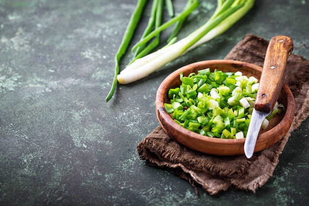 Cebollas verdes picadas sobre fondo de hormigón