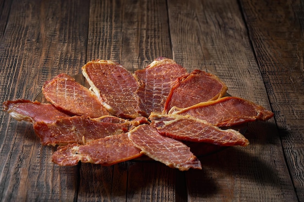 La cecina preparada se coloca en un plato. Fondo marrón de madera