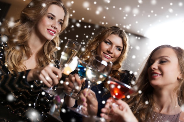 celebração, amigos, despedida de solteira e conceito de férias - mulheres felizes bebendo champanhe e coquetéis no bar do clube noturno