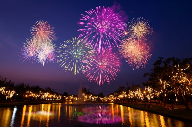Foto celebração colorida dos fogos-de-artifício e o fundo da luz da noite da cidade.