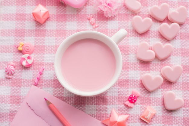 Celebração de feriado do dia dos namorados com copo de leite na toalha de mesa-de-rosa