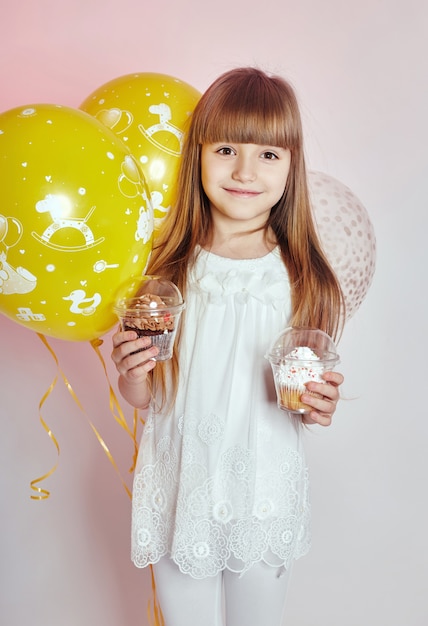 Celebração de moda menina criança com balões, moda infantil e roupas. Garota posando no estúdio