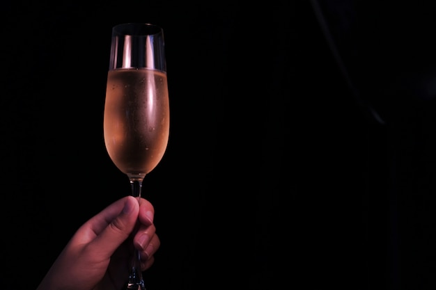 Foto celebração de natal ou ano novo mãos de pessoas com óculos de cristal cheios de champanhe perto da árvore de natal e espaço para o seu texto.