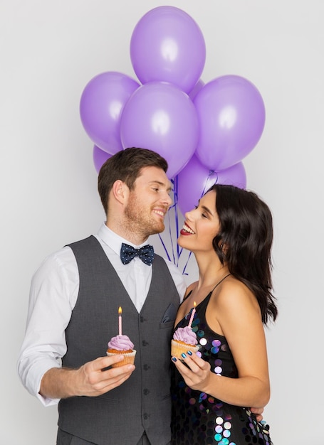 Foto celebración aniversario y vacaciones concepto pareja feliz con globos ultravioleta y pasteles en la fiesta de cumpleaños