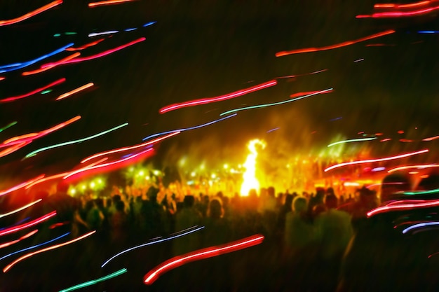 Celebración borrosa en la fiesta de baile al aire libre de verano y espectáculo de luces en el festival de música