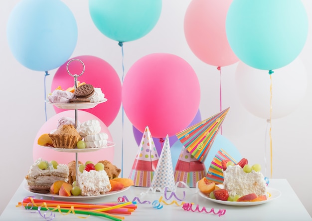 Celebración de cumpleaños con pastel y globos de colores