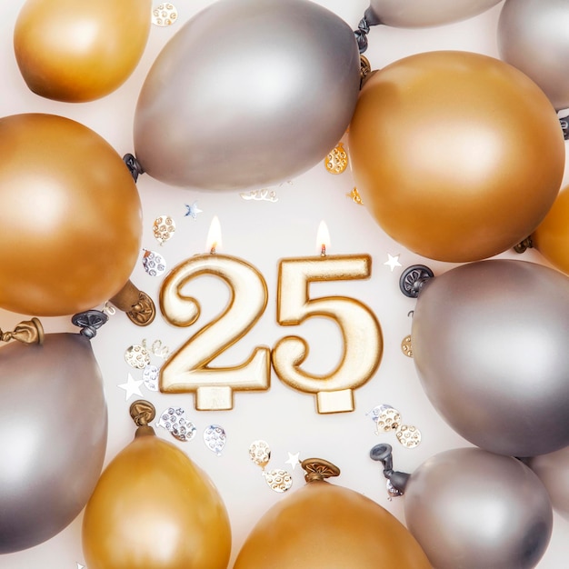 Foto celebración de cumpleaños vela número 25 con globos dorados y plateados