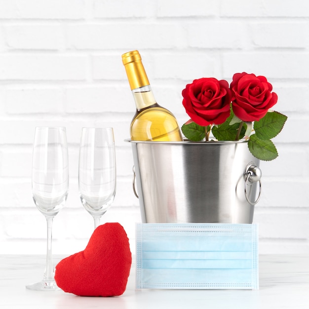 Celebración del Día de San Valentín con concepto de protección de vino, ramo y mascarilla durante estos tiempos difíciles.