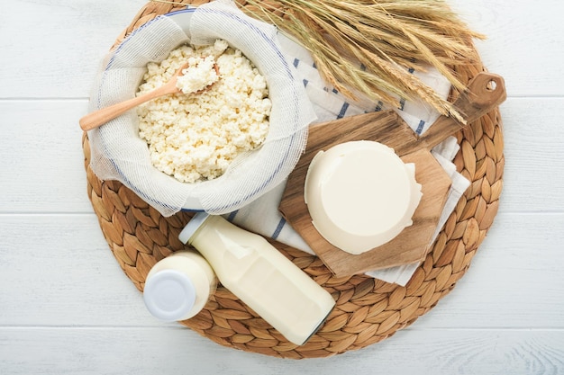 Celebración festiva judía de Shavuot Leche y queso trigo maduro y crema de frutas sobre fondo de madera blanca Productos lácteos sobre fondo de madera blanca Concepto de Shavuot Vista superior Maqueta