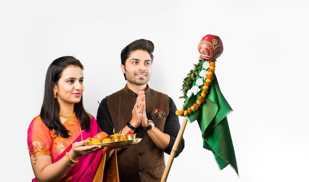 Celebración de Gudi Padwa - pareja inteligente india realizando puja en año nuevo hindú, aislado sobre fondo blanco.