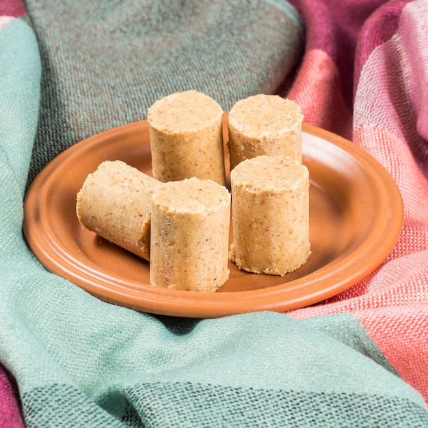 Celebración de junio. Cacahuete brasileño dulce llamado PaÃ§oca en un plato sobre una tela de color.