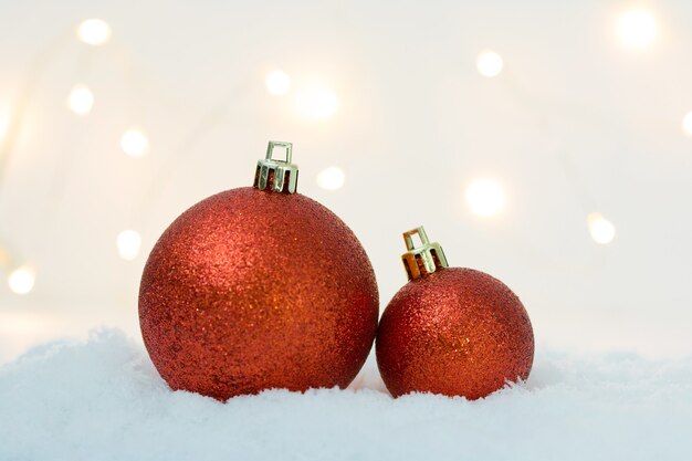 Celebración de Navidad con decoración de bolas sobre fondo de nieve luz bokeh