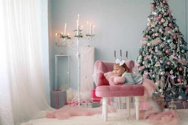 Celebración de Navidad. Niña niño jugando cerca del árbol de Navidad.