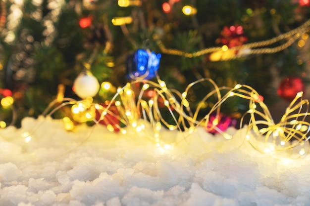 Celebración navideña nieve y decoración del árbol de Navidad sobre fondo borroso diseño de fondo de navidad luces bokeh