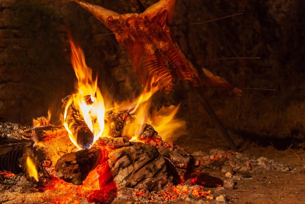 Celebración nocturna con una hoguera para asar carne en una barbacoa