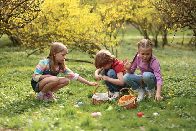 Celebración de Pascua Niños lindos cazando huevos al aire libre