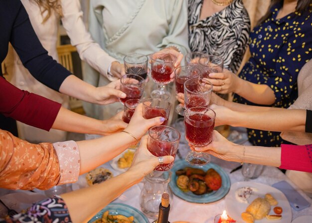 Celebración de personas sosteniendo copas de vino blanco haciendo un brindis