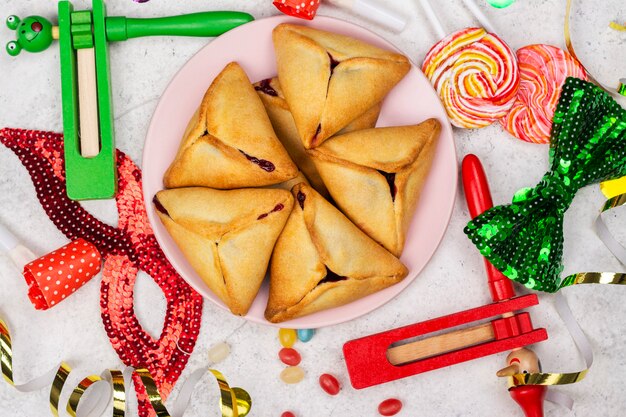 Celebración de Purim. Carnaval judío. Tortas de galletas hamantaschen judías tradicionales y mascarada de Purim