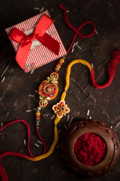 Celebración de Raksha Bandhan con un elegante Rakhi, Rice Grains, Kumkum y una caja de regalo. Una pulsera tradicional india que es un símbolo de amor entre hermanos y hermanas.