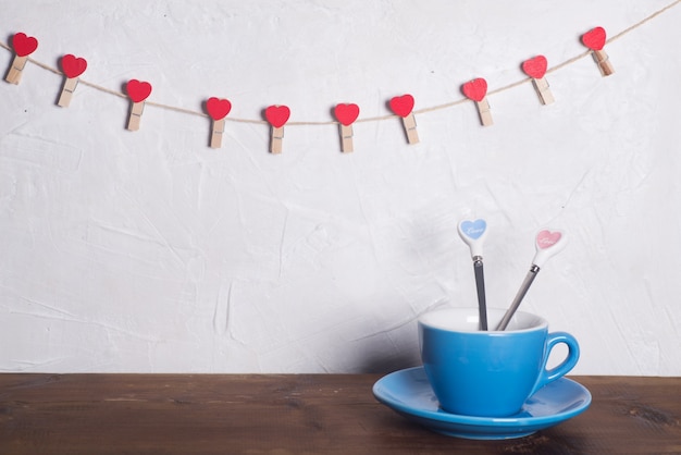 Celebración de San Valentín con corazones y tazas sobre fondo bokeh