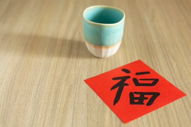 Celebraciones del Año Nuevo Chino y del Año Nuevo Lunar con sobre rojo y té caliente. La palabra china significa: bendición, felicidad y suerte.