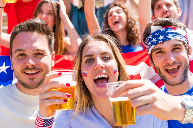 Celebrações do 4 de julho, os americanos aplaudindo cervejas e bandeiras dos eua