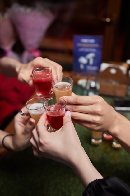 Celebran con vasos de alcohol en las manos Felices amigas que se divierten