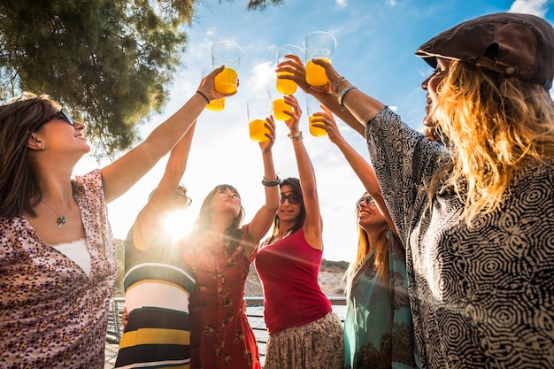 Celebrando la amistad o el éxito, el equipo trabaja al aire libre con jugo de colores y 7 hermosos