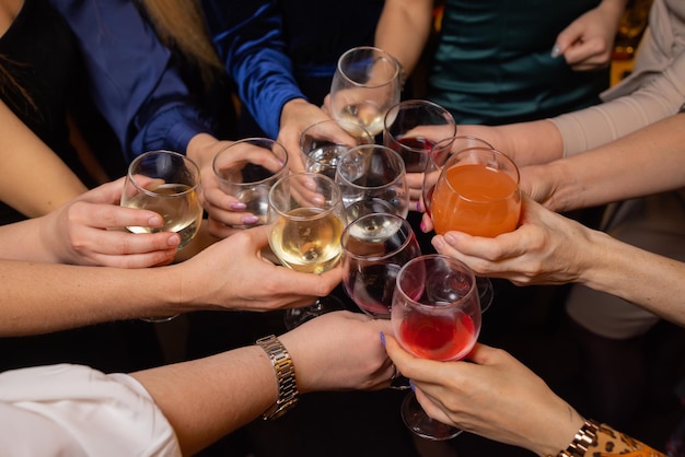 Celebrando com copos de álcool nas mãos amigas felizes se divertindo