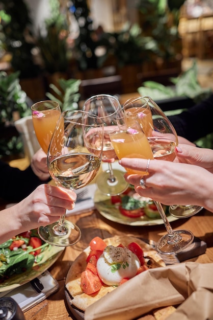 Celebrando com copos de álcool nas mãos amigas felizes se divertindo