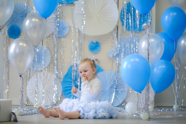 Celebrando el cumpleaños de una niña de 1 año. Chica en una falda azul.