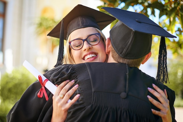 Celebrando nossa grande conquista foto de um jovem casal se abraçando no dia da formatura