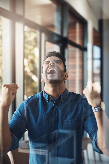 Celebrando o empresário vencedor e animado com gesto de bomba de punho e expressão sim, sentindo-se animado jovem empresário masculino feliz com emoção aplaudida para comemorar a vitória ou o grande sucesso nos negócios