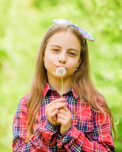 Celebrando el regreso del verano. El diente de león es hermoso y está lleno de simbolismo. El verano está aquí. Flor del jardín de verano. Adolescente de la muchacha vestido de fondo de la naturaleza de la camisa a cuadros del estilo rústico del país. Pide un deseo.