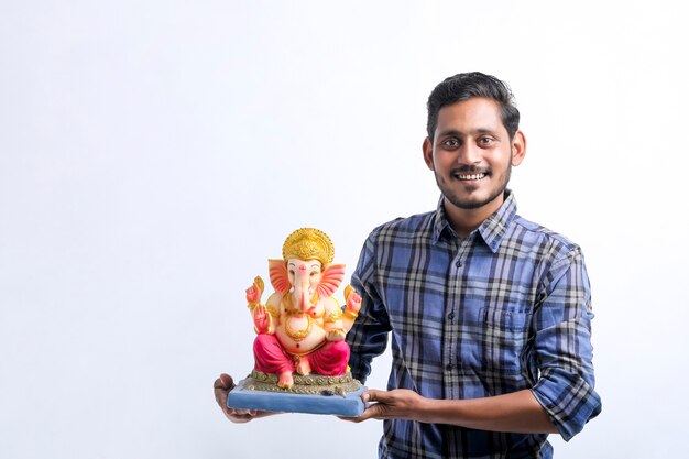 Celebre el festival de ganesha. Joven apuesto indio con el señor ganesha.