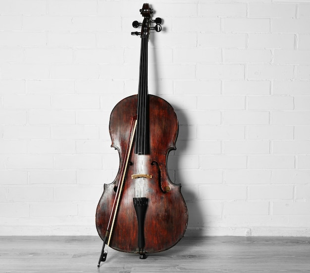 Cello auf weißer Backsteinwandoberfläche