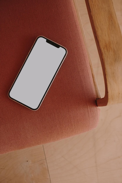 Celular de tela em branco na cadeira vintage Modelo de aplicativo de site de blog minimalista estético de vista superior plana Copiar maquete de smartphone de espaço