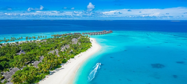 Cena aérea da praia da ilha das Maldivas. Areia branca, lagoa de mar claro, palmeiras. Férias de luxo