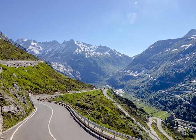 Cena alpina majestosa com uma passagem de montanha de Grimsel pavimentada vazia na Suíça