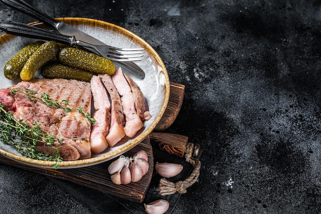 Cena de barbacoa Filetes de cerdo de carne de cuello en plato con hebs Fondo negro Vista superior Espacio de copia