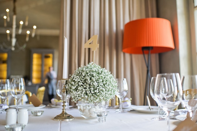 Cena de boda festiva, la mesa de los novios decorada con flores.