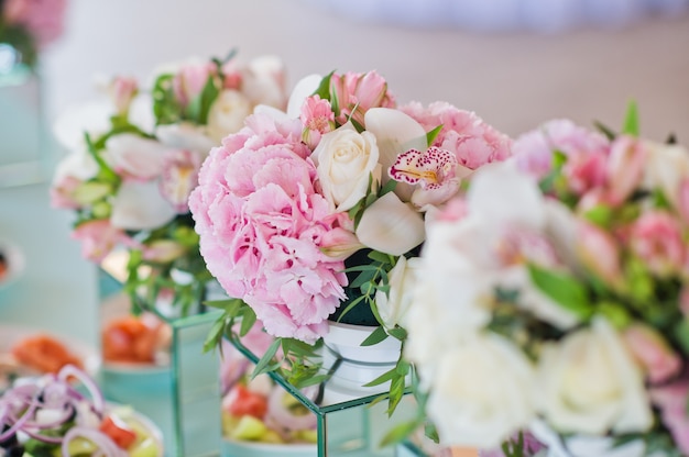 Cena de boda en el restaurante, mesas decoradas con jarrones de rosas.