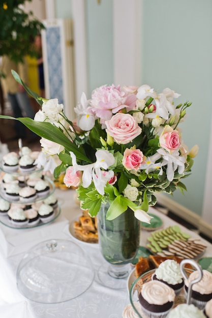 Cena de boda en el restaurante, mesas decoradas con jarrones de rosas.