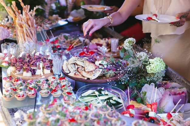 Cena buffet un banquete bellamente decorado con una variedad de bocadillos.