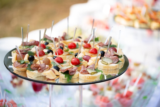 Cena buffet con mesa de catering, banquete bellamente decorado con variedad de diferentes bocadillos y aperitivos en eventos corporativos de fiesta de cumpleaños o recepción de bodas, canapés, delicatessen