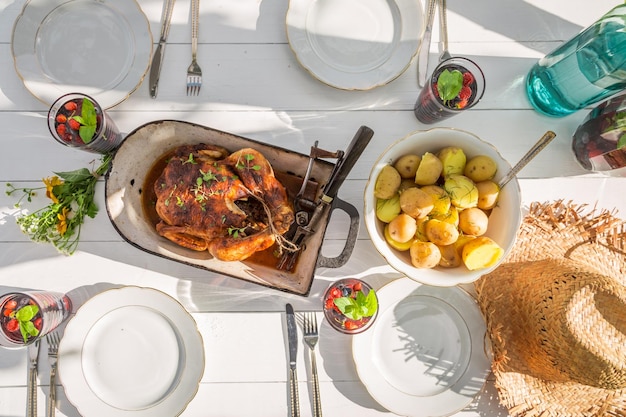 Cena casera con papas y pollo servida en el jardín